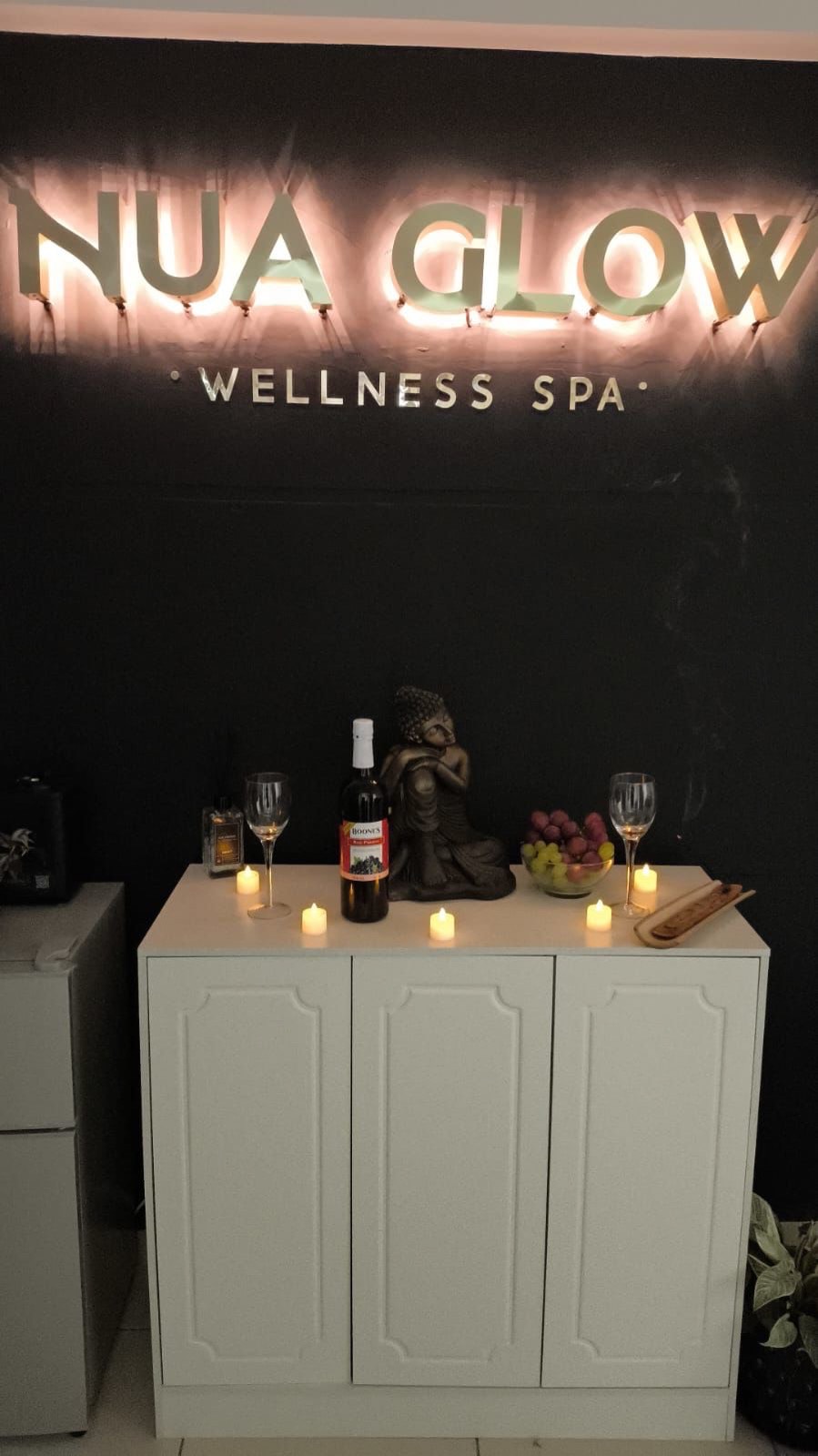 Recepción de NUA Glow Wellness Spa con letrero iluminado